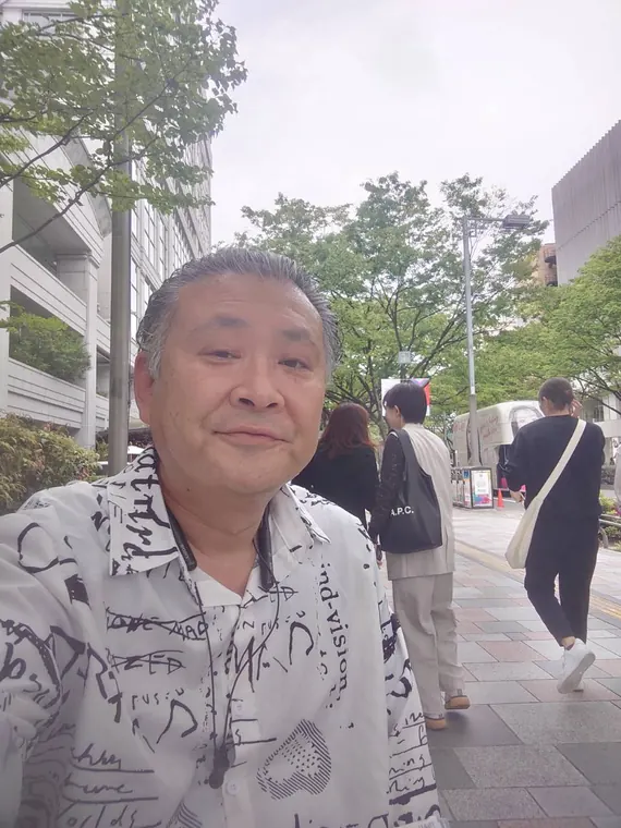 街を歩くカジュアルな装いの吉岡直哉